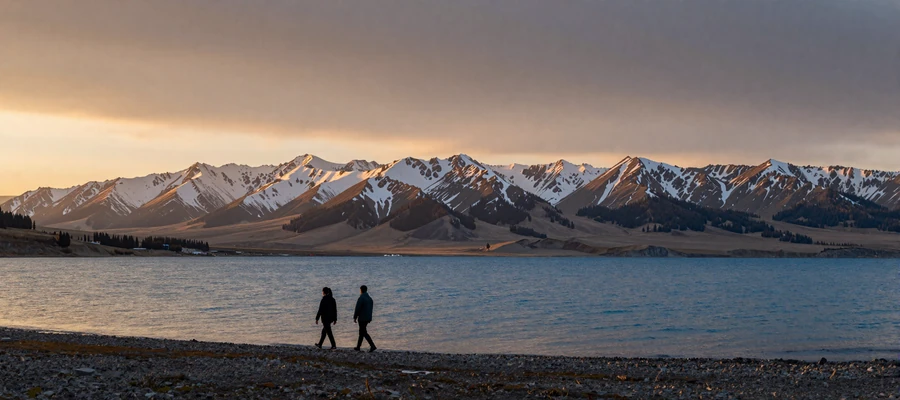 Scenic Issyk-Kul lake surrounded by Tien Shan mountains at golden hour in Kyrgyzstan