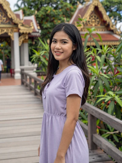 Thai woman Suki from Chiang Mai posing near a temple bridge seeking international dating