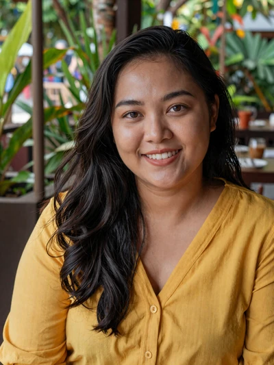Indonesian woman Rina from Jakarta with cheerful smile in garden restaurant setting